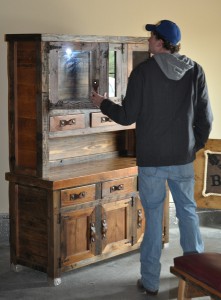 A Meander customer looks over a cupboard made from re-claimed barn wood at T & D Barnwood Rustics in Dawson.