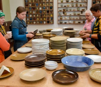 People looking at pottery at one of the Meander artists' studios.