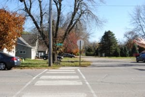 Street in a residential neighborhood with an empty crosswalk.