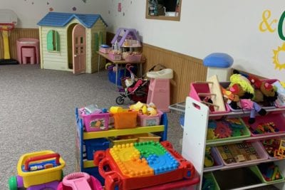 Space filled with childrens toys. Wagons, blocks, playhouses.