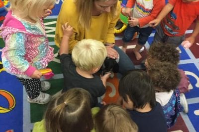 Toddlers gathered arond the teacher.